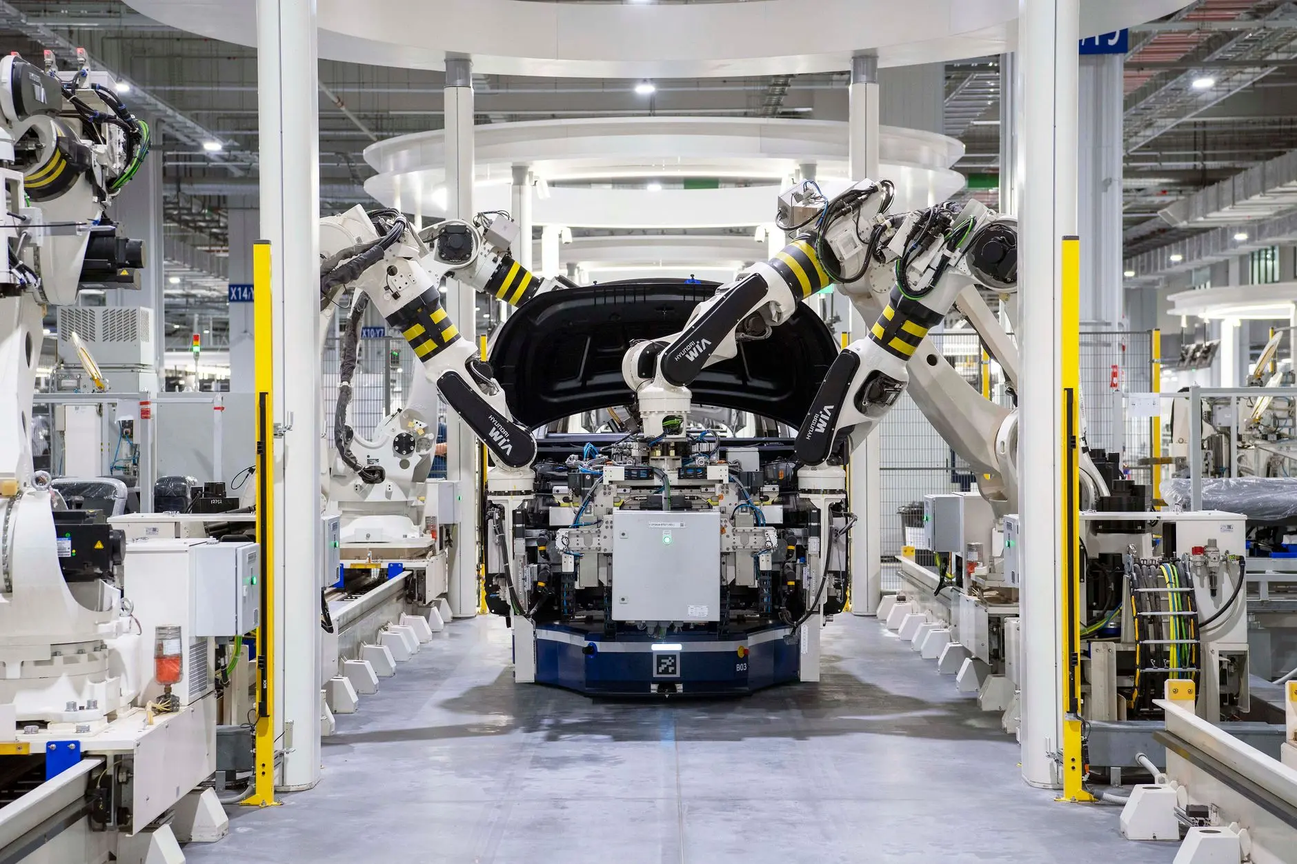 Automated vehicle assembly line showing robotic arms manufacturing automotive parts in a modern industrial plant