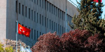 Turkish flag flying outside an official government building representing international relations and policy.